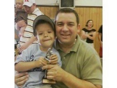 Gaten Matarazzo is holding the story as he is sitting on Gaten Matarazzo Sr.'s lap.